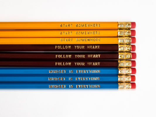 Set of 9 foil engraved pencils in the colors yellow, dark red, and bright blue. Each pencil has a unique quote on the pencil, "Start Somewhere" "Follow Your Heart" "Mindset is Everything"