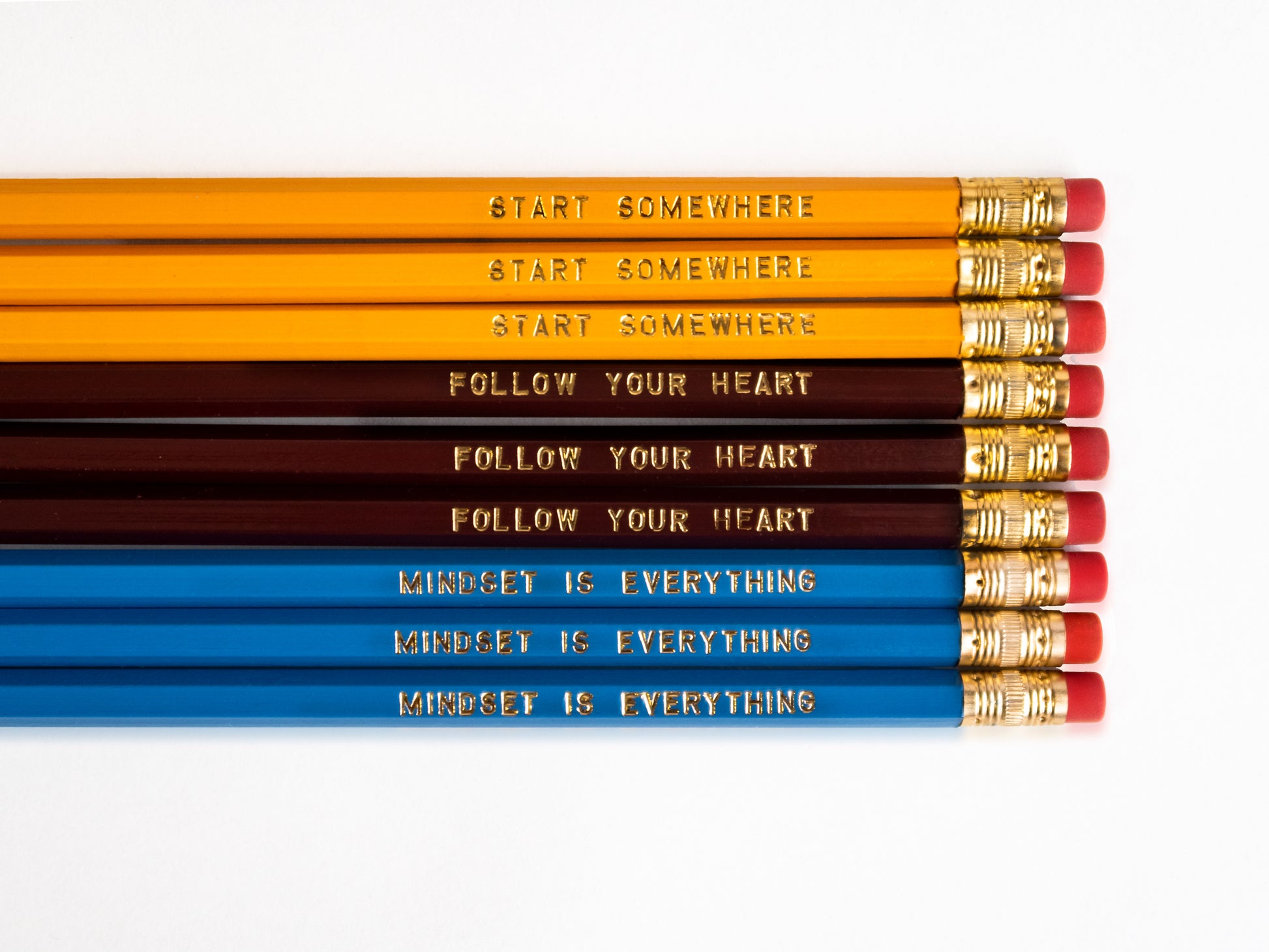 Set of 9 foil engraved pencils in the colors yellow, dark red, and bright blue. Each pencil has a unique quote on the pencil, "Start Somewhere" "Follow Your Heart" "Mindset is Everything"